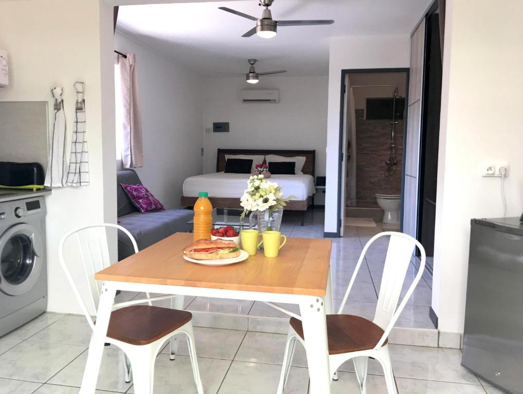 a kitchen and living room with a table and chairs at Iris suite in Punaauia