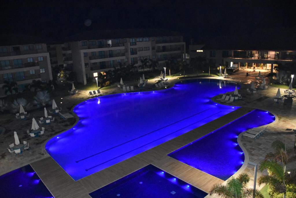 una vista aérea de una piscina por la noche en Apartamento Eco Life, en Porto de Galinhas