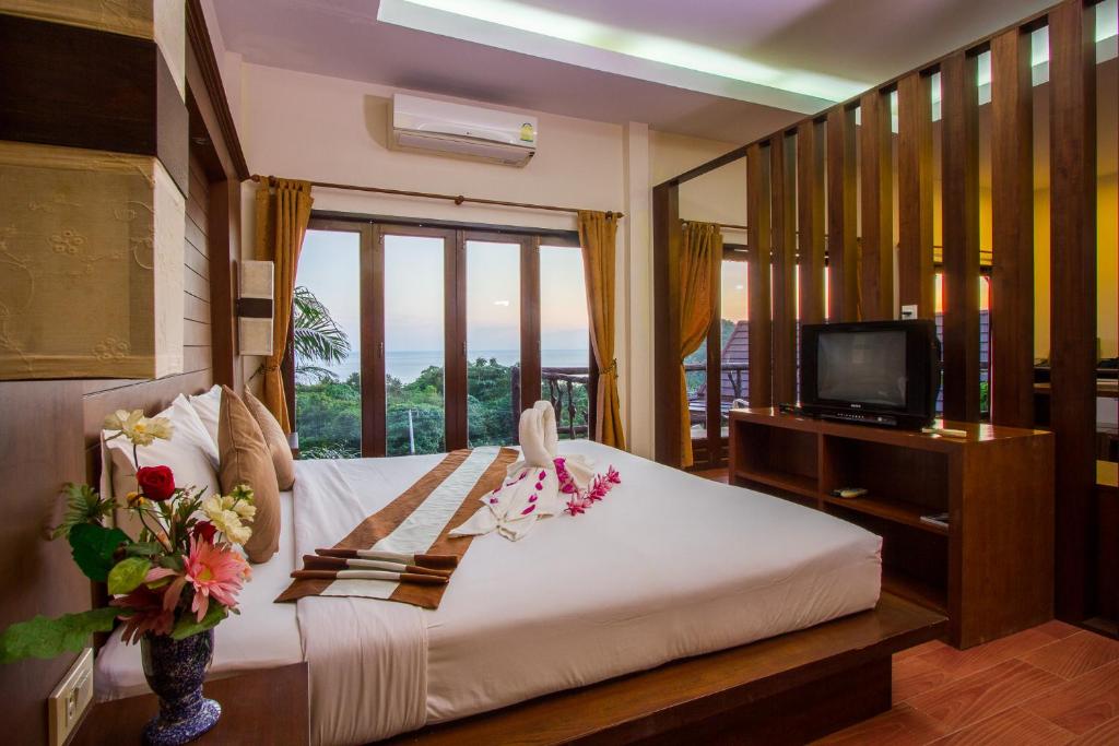 a bedroom with a bed with a tv and a window at Phuchawee Lanta in Ko Lanta