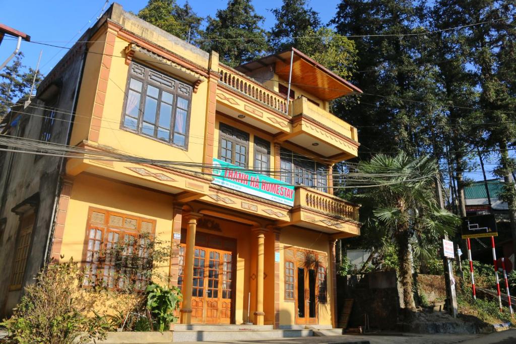 a yellow house with a balcony on a street at Thanh Ha Homestay Sapa in Sa Pa