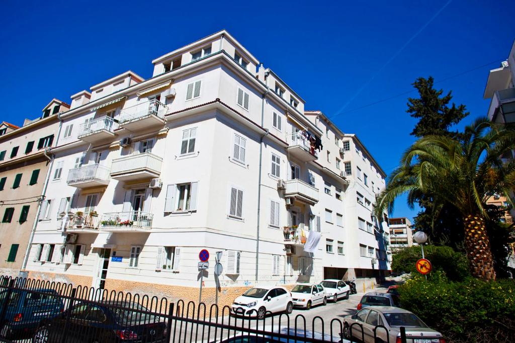 ein weißes Gebäude mit davor geparkt in der Unterkunft Split Apartments Peric in Split