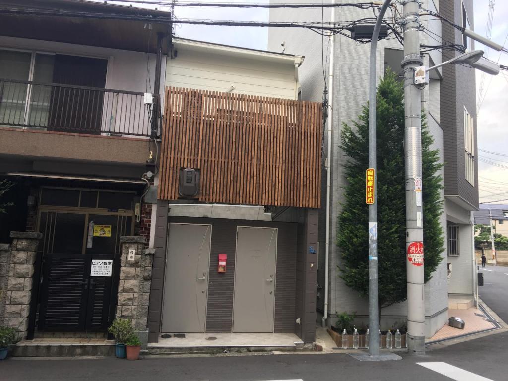 budynek z dwoma drzwiami po stronie ulicy w obiekcie Osaka Tengachaya Guesthouse SAYURI II w Osace