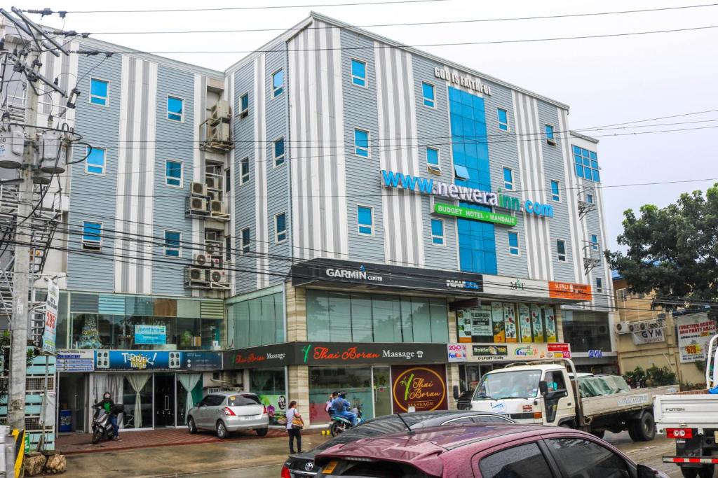 ein großes Gebäude an einer Stadtstraße mit Autos in der Unterkunft RedDoorz Plus New Era Budget Hotel Mandaue former RedDoorz Plus near UV Mandaue Cebu in Cebu City