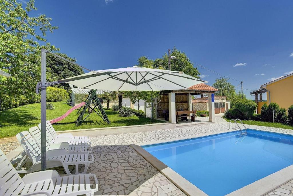 - une piscine avec des chaises, un parasol et une balançoire dans l'établissement Villa Semy, à Lindar