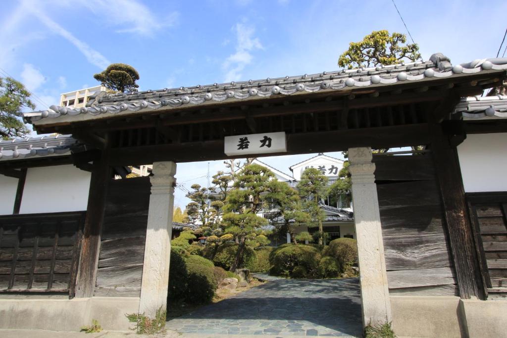 una puerta con un cartel en un jardín en Wakariki Ryokan en Yanagawa