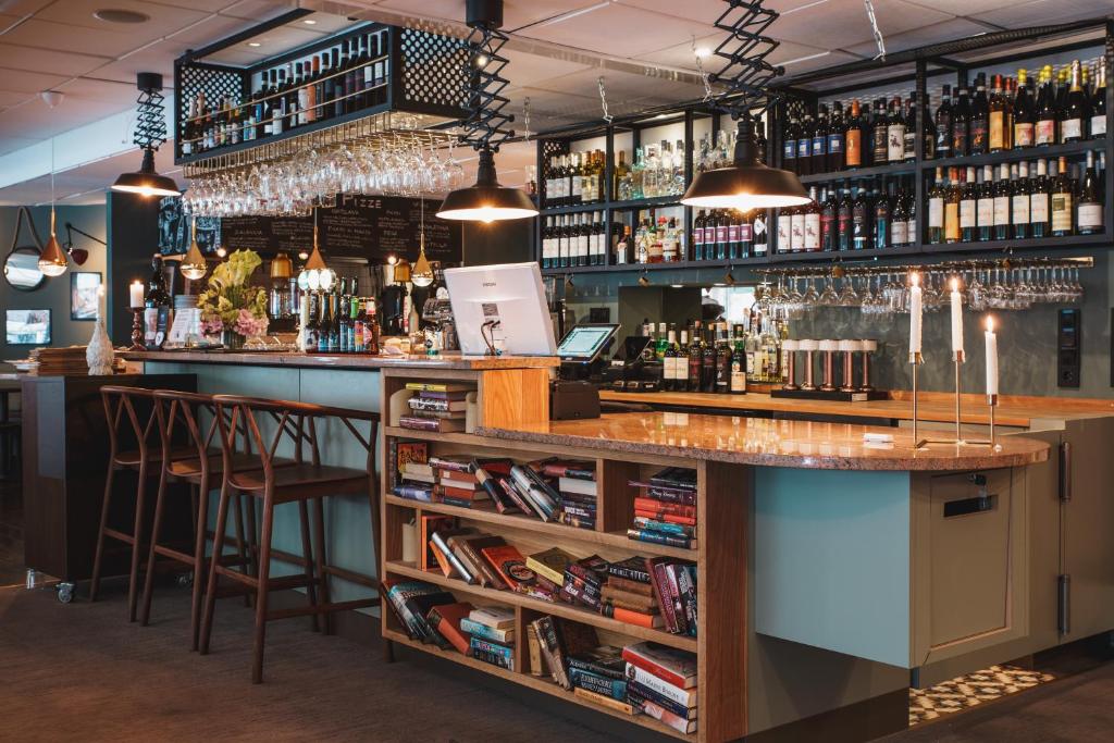 a bar with two stools and a counter with alcohol at Hotel Point in Stockholm