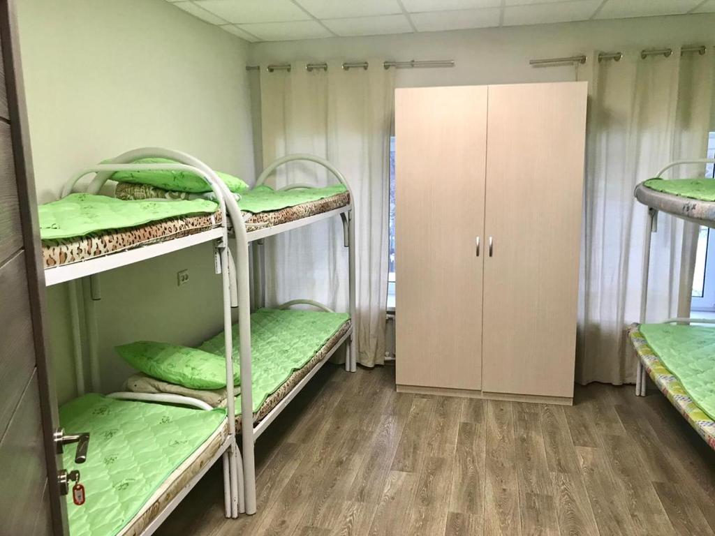 モスクワにあるRomashka Hostelの二段ベッド2台とクローゼットが備わる客室です。