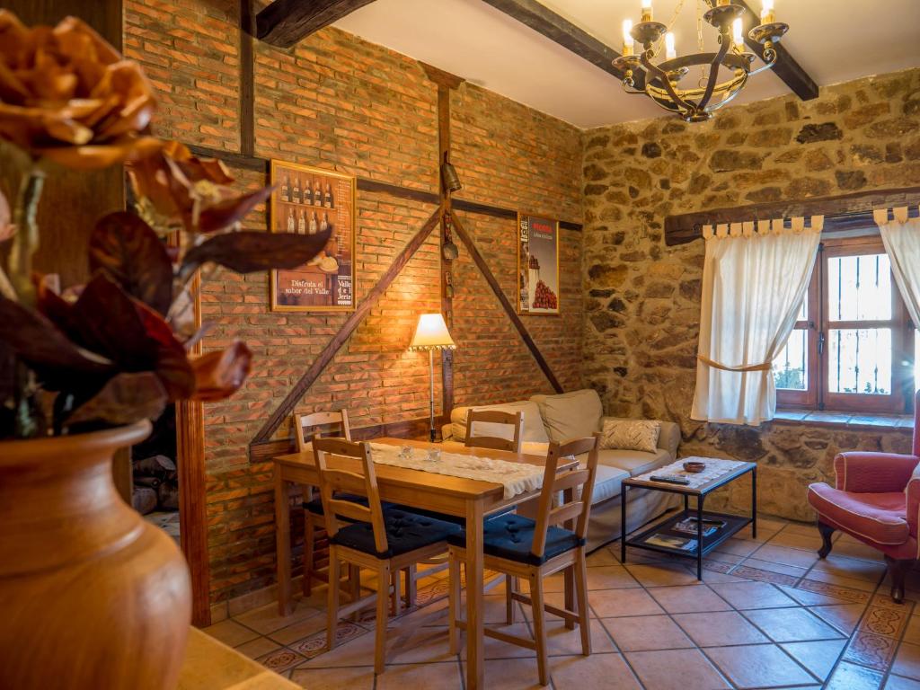 a dining room with a table and chairs and a couch at El Cerrillo in Navaconcejo