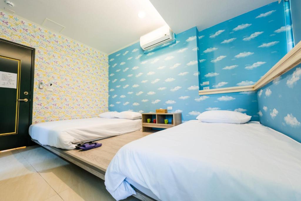 Duas camas num quarto com paredes azuis em ManMan House Ruifang em Ruifang