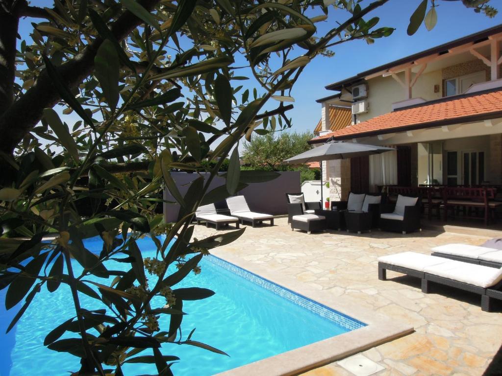 a villa with a swimming pool and a house at Holiday Home Villa Ivan in Umag