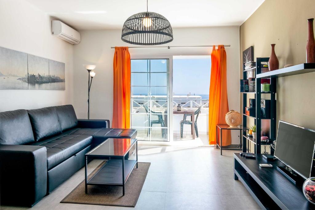 Una sala de estar con un sofá y un televisor. en Apartamentos Panelo, en Puerto del Carmen