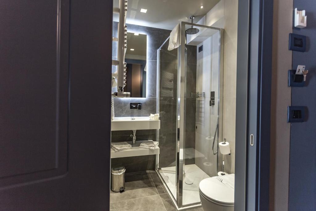a bathroom with a shower and a toilet and a sink at Hotel Tiziano in Venice