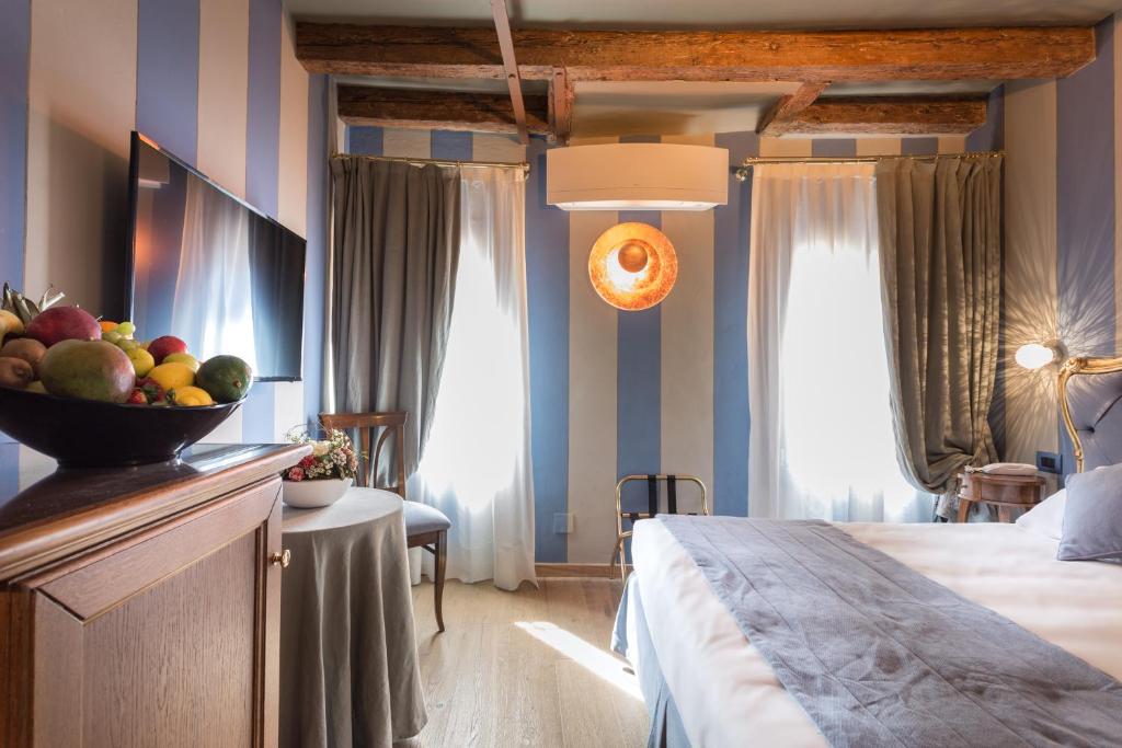 a hotel room with a bowl of fruit on a buffet at Hotel Tiziano in Venice