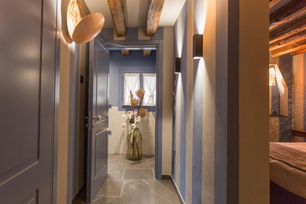 a hallway with a blue door and a vase of flowers at Hotel Tiziano in Venice