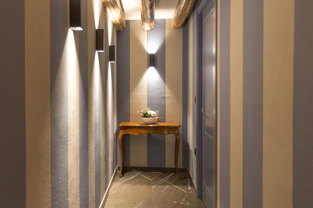 a hallway with striped walls and a table with flowers at Hotel Tiziano in Venice
