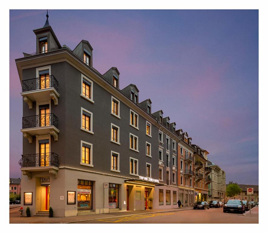 Un gran edificio en una calle de la ciudad por la noche. en Trip Inn Zurich Hotel, en Zúrich