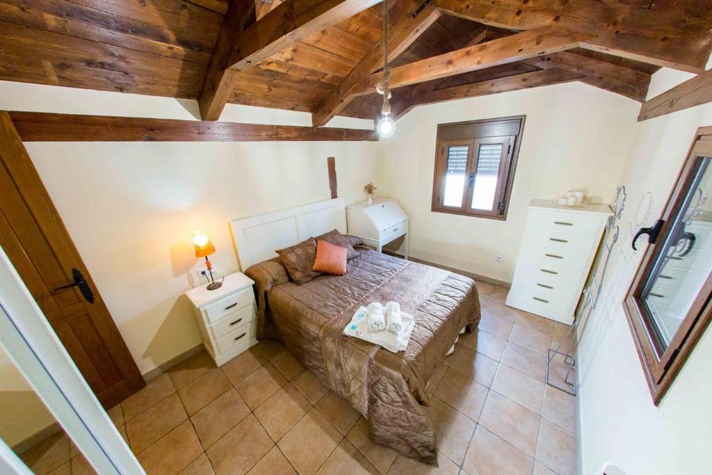 een slaapkamer met een bed en een houten plafond bij Casa Torre Mudéjar in Toledo