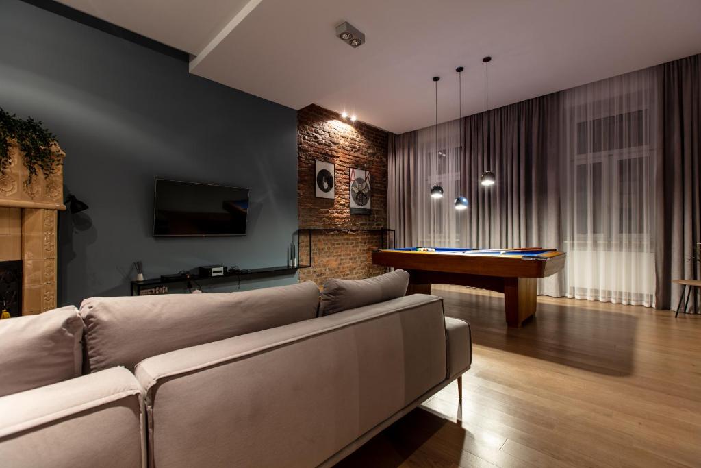 un soggiorno con divano e tavolo da biliardo di Deco Apartments Mariacka 8 a Katowice