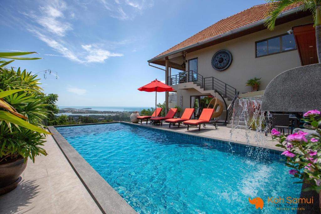 een zwembad met oranje stoelen en een huis bij Villa Macha in Chaweng Beach