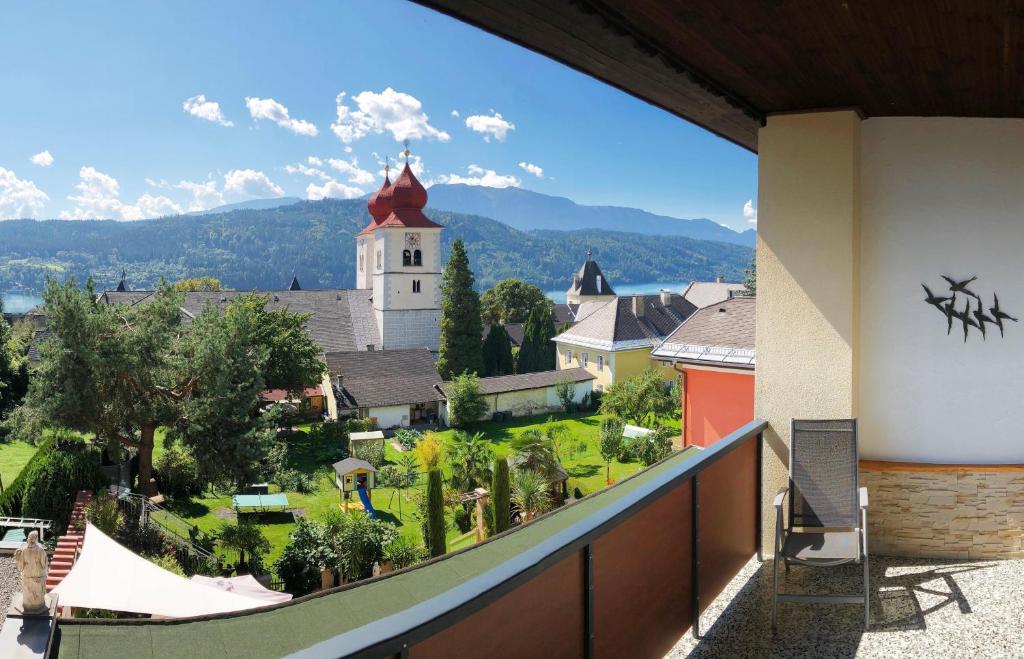 a balcony with a view of a town and a church at Appartements Diana in Millstatt