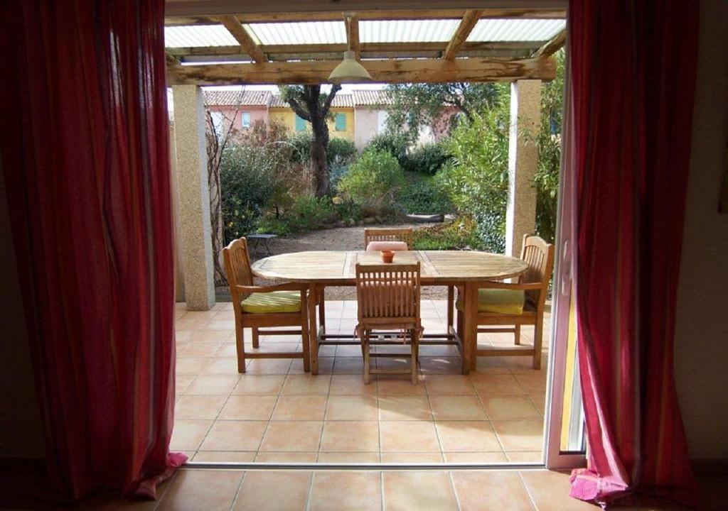 a dining room table and chairs on a patio at LAURENCE in Porto-Vecchio