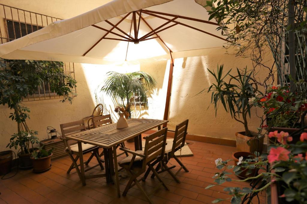 un patio con mesa, sillas y sombrilla en Grotte Flat, en Roma