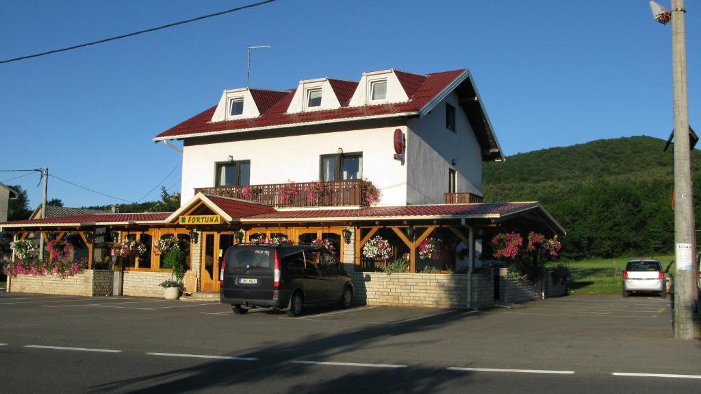 um edifício com um carro estacionado em frente em Guesthouse Fortuna em Korenica