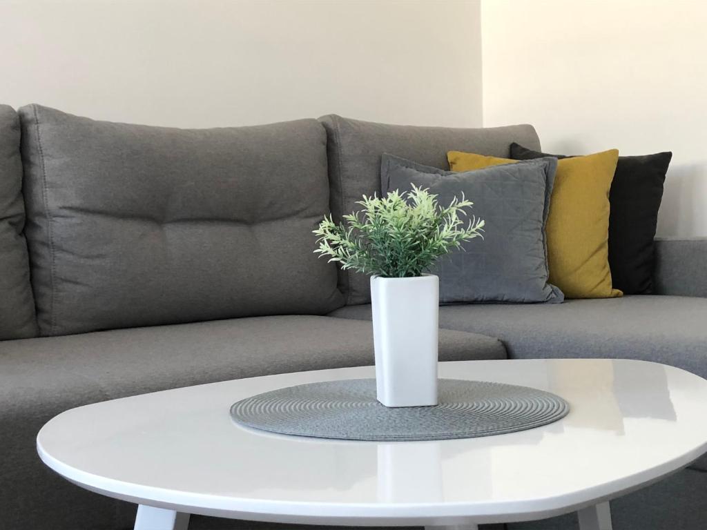 una mesa de café blanca frente a un sofá en La Fontana, en Belgrado