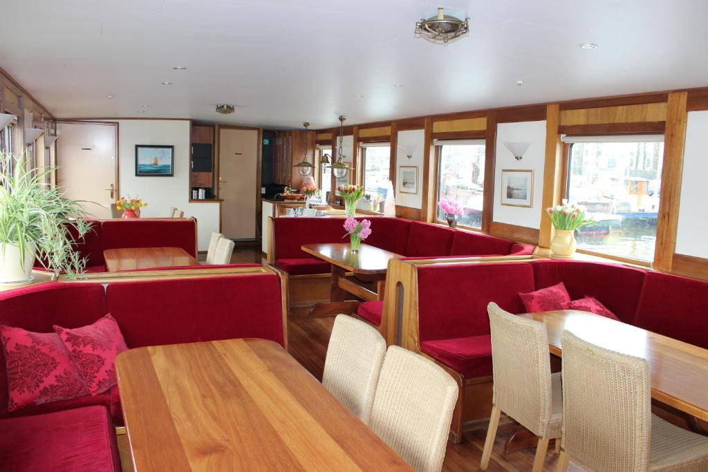 a restaurant with red booths and wooden tables and chairs at Felicitas in Amsterdam