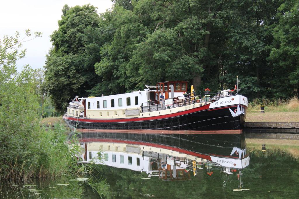 a boat in the water with its reflection in the water at Felicitas in Amsterdam