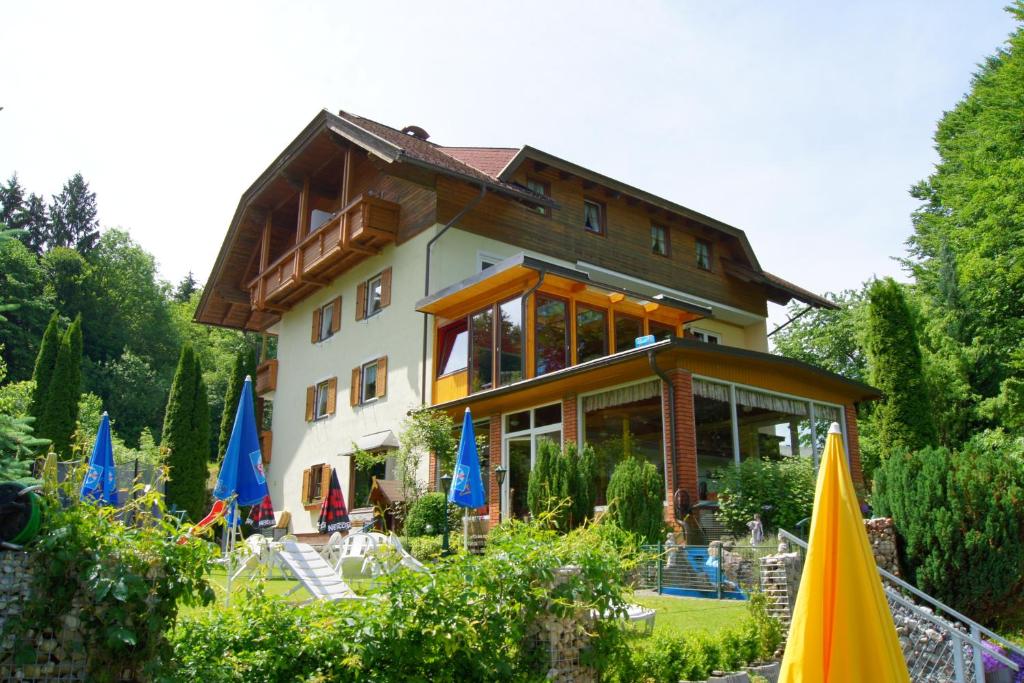 a building with blue and yellow umbrellas in front of it at Appart-Pension Seehang in Velden am Wörthersee