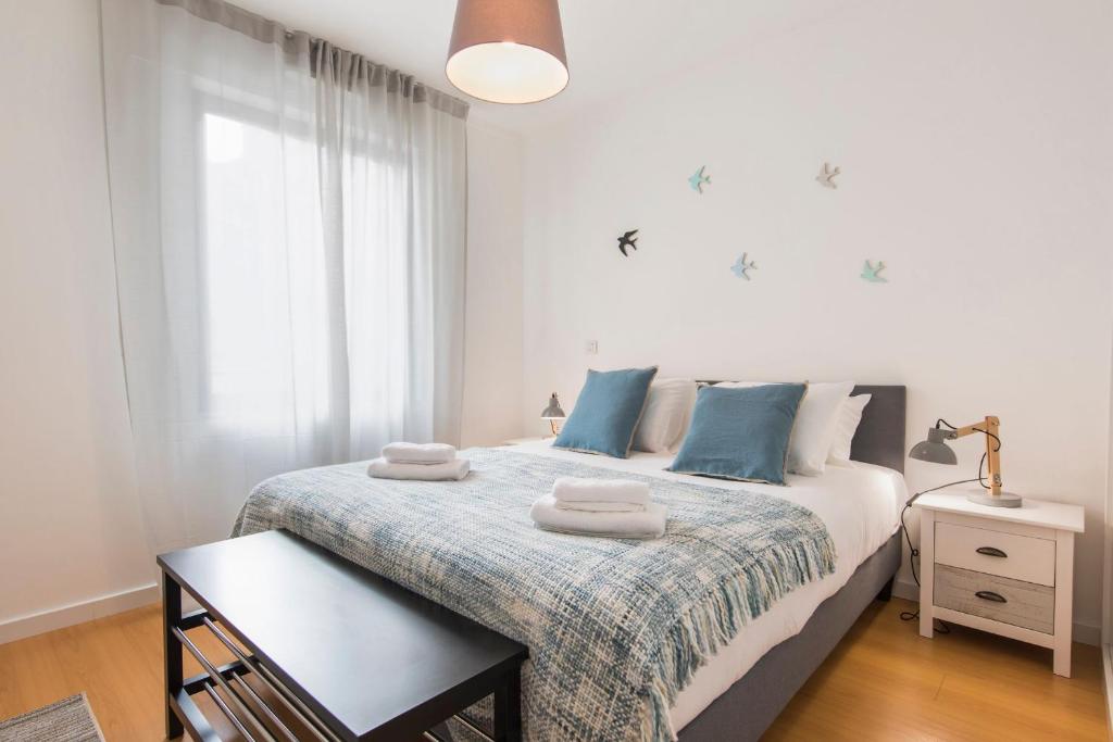 リスボンにあるLovelyStay - Family-Friendly Apartment Downtownのベッドルーム1室(青い枕のベッド1台付)