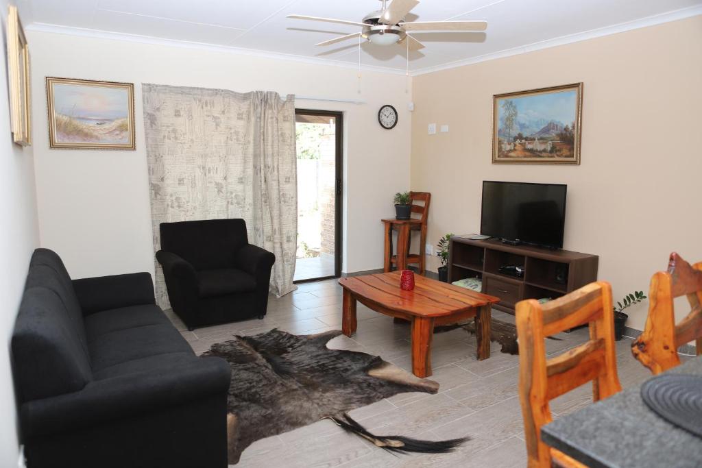Lodge Huge Dassie في بيلا بيلا: غرفة معيشة مع أريكة وتلفزيون