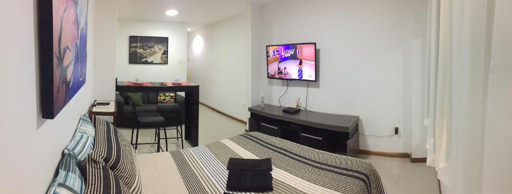 Dormitorio con cama, escritorio y TV en Studio Botafogo Beach, en Río de Janeiro