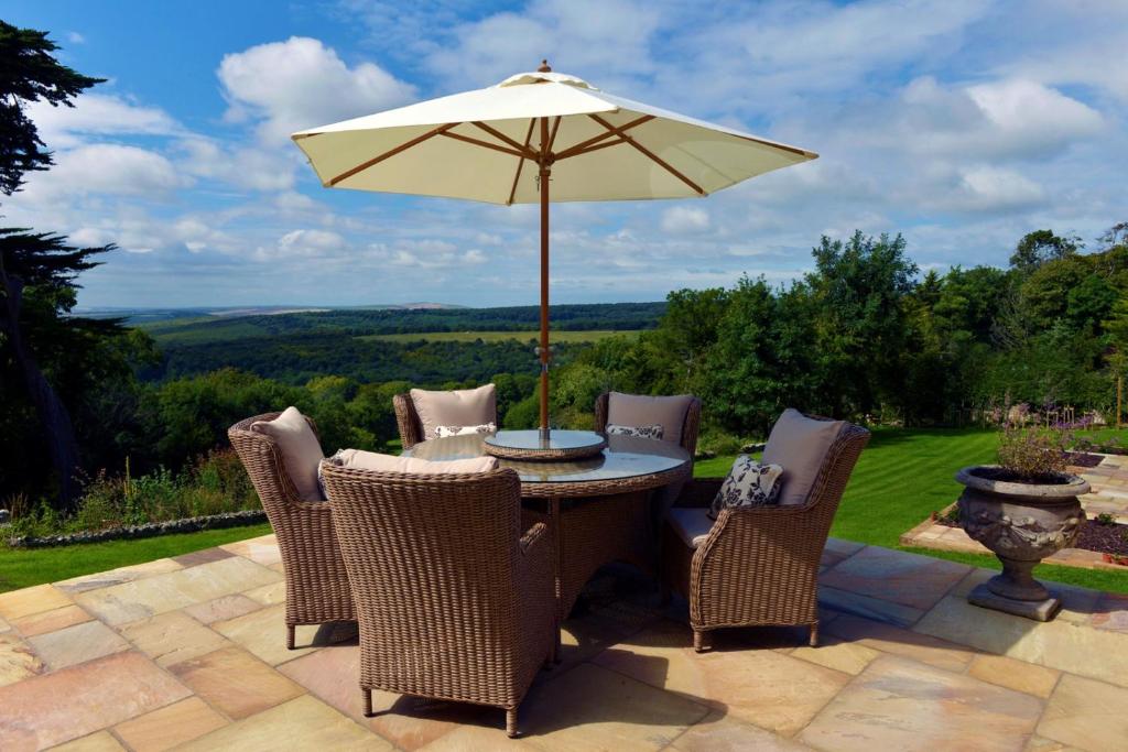 a table and chairs with an umbrella on a patio at Little Friston Lodge in Eastbourne