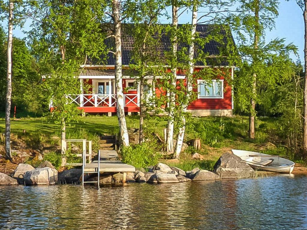 a house on the shore of a lake with a boat at Holiday Home Tervaleppä by Interhome in Torvoila