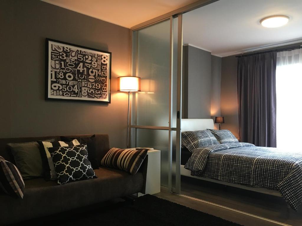 een slaapkamer met een bed, een bank en een raam bij D-condo mine in Kathu