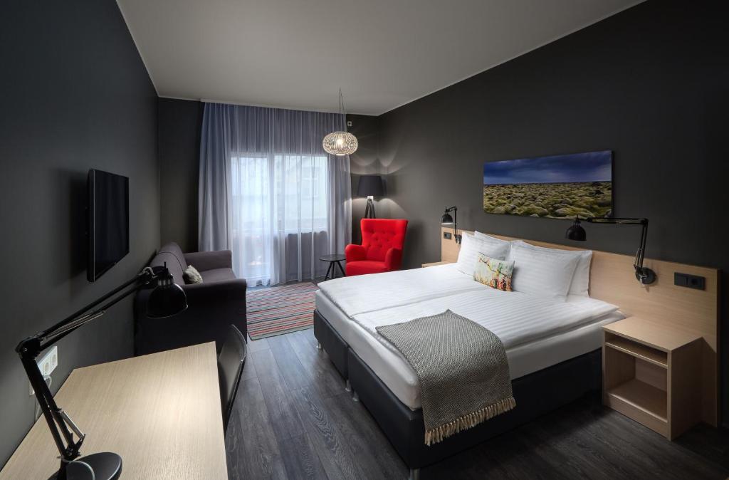 
a bedroom with a bed, a desk, and a lamp at Alda Hotel Reykjavík in Reykjavík

