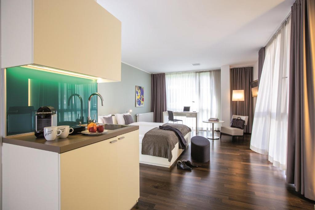 a hotel room with a bed and a kitchen at THE FLAG Zürich in Zürich