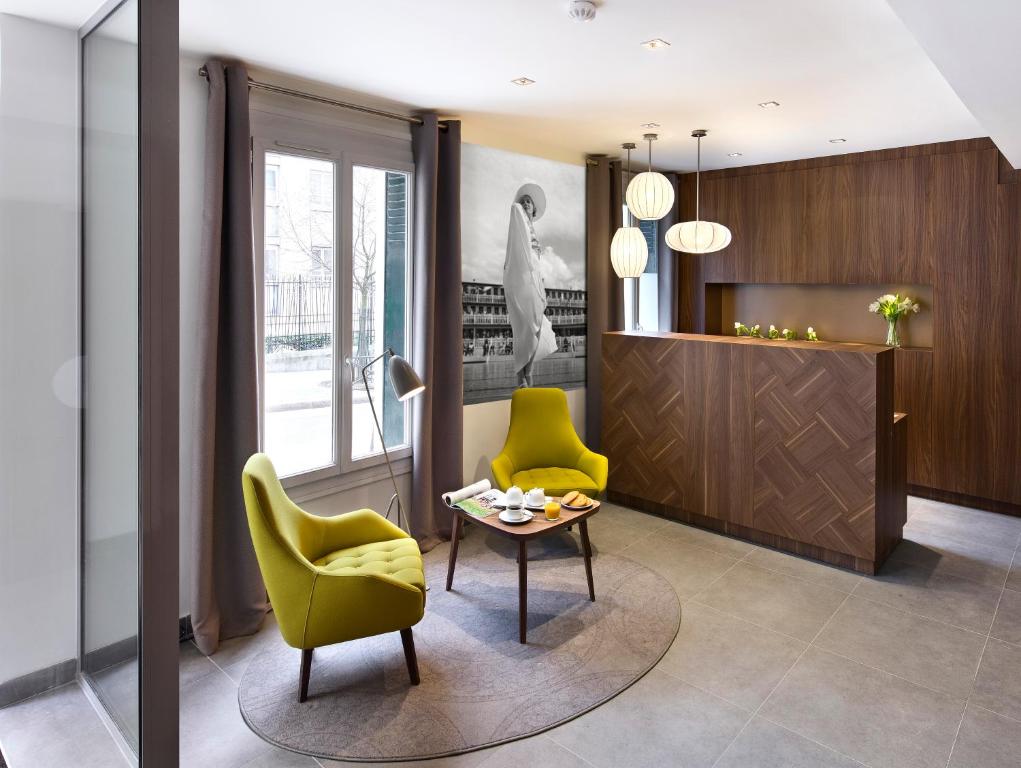 パリにあるベストウエスタン プラス 61 パリ ネーション ホテルのリビングルーム(黄色い椅子2脚、テーブル付)