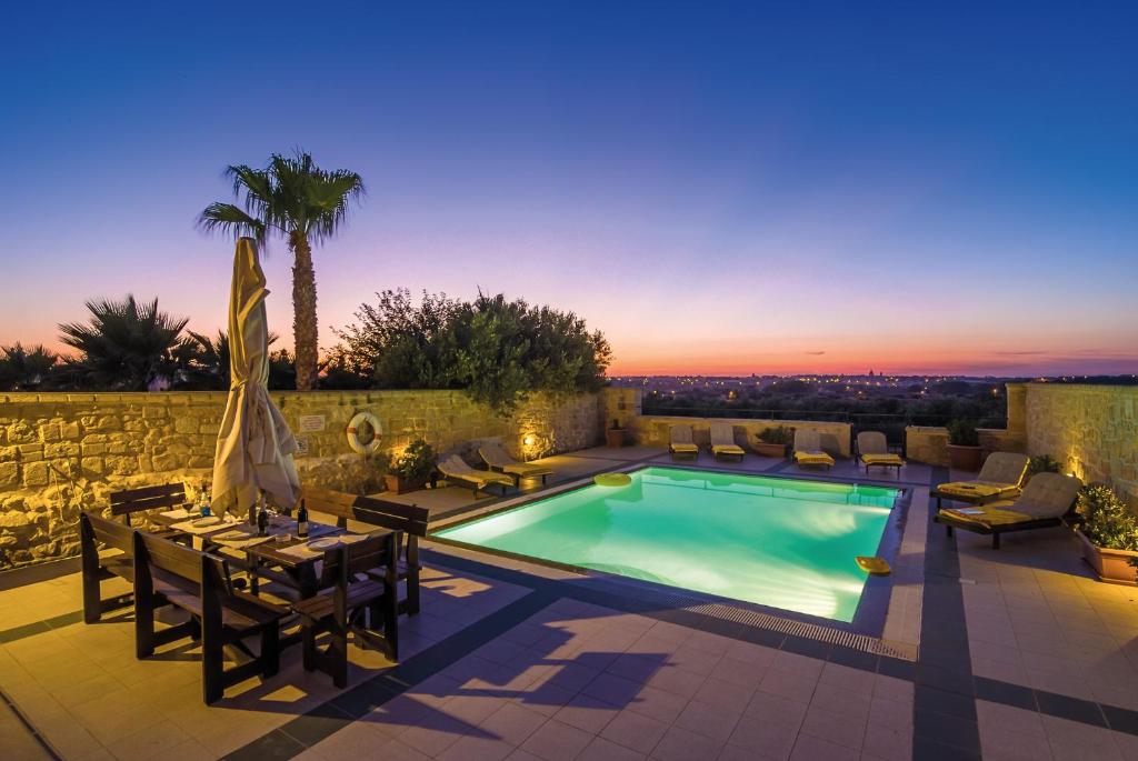 a villa with a swimming pool and a table and chairs at Blueberry Hills in Żejtun