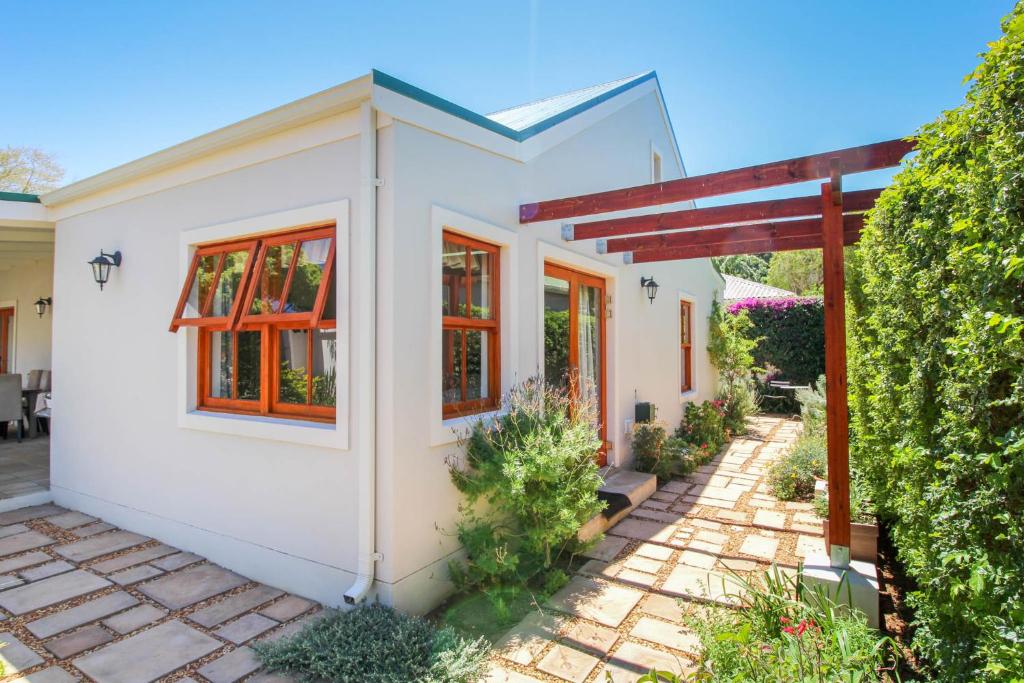 a small white house with red windows and a patio at The Annexe at No. 5 in Montagu
