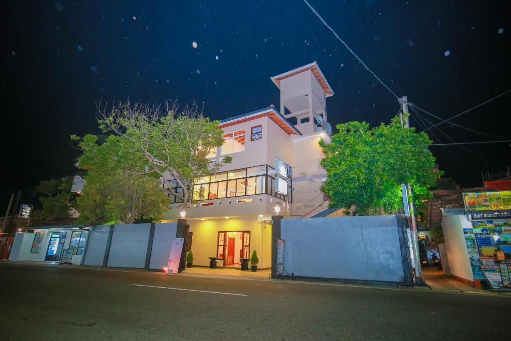 a large white building at night on a street at Villa Paradise in Hikkaduwa