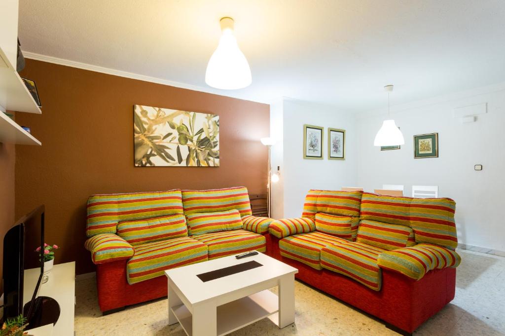 un soggiorno con 2 divani e un tavolo di Holi-Rent Albareda a Siviglia
