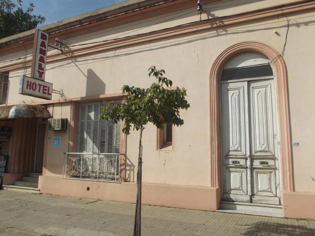 un árbol frente a un edificio con una puerta en Hotel Danaly, en Salto