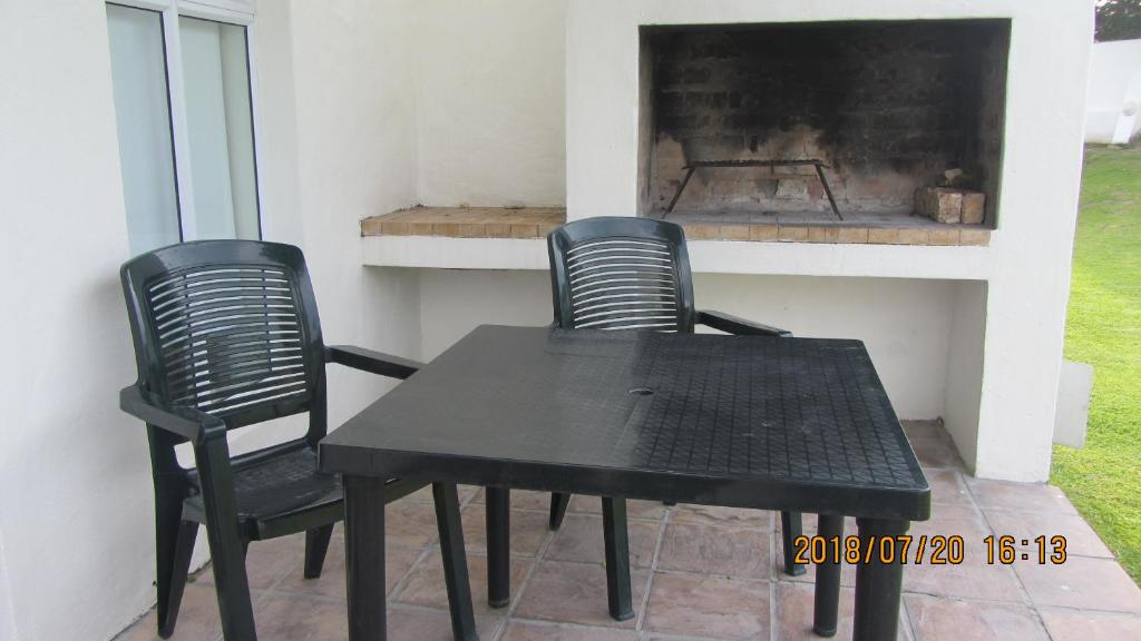 two black chairs and a table in front of a fireplace at The Tides 7 in Struisbaai