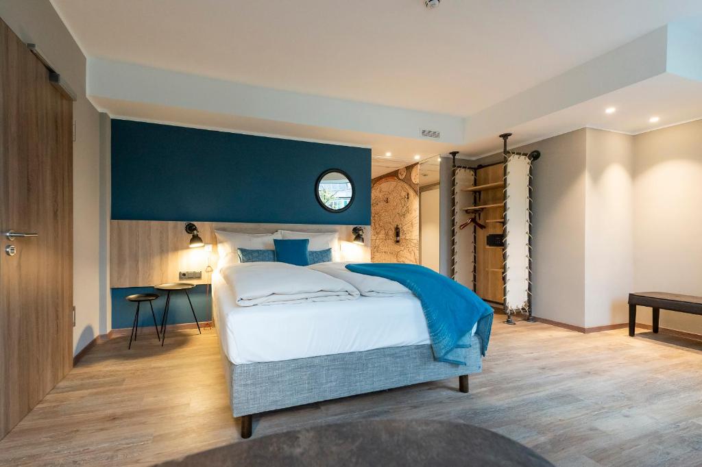 a bedroom with a large bed with a blue wall at HARBR. hotel Konstanz in Konstanz