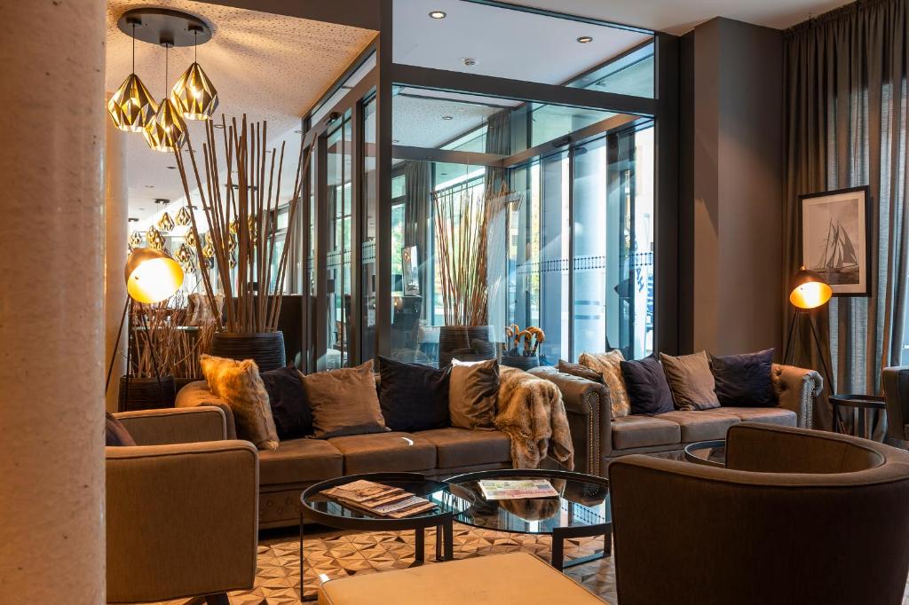 a living room with a couch and a table at HARBR. hotel Konstanz in Konstanz