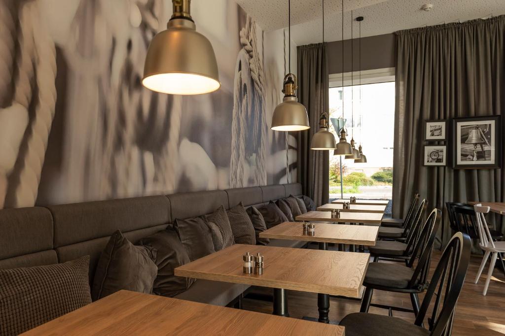 a row of tables in a restaurant with lights at HARBR. hotel Konstanz in Konstanz