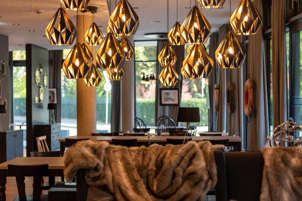a dining room with a table and chandeliers at HARBR. hotel Konstanz in Konstanz